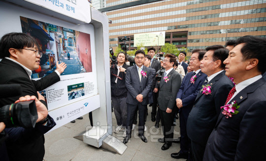 김진표 국회의장을 비롯한 주요 내빈들이 20일 서울 종로구 광화문 광장에서 열린 '제59회 한국보도사진전 개막식'에 참석해 전시된 사진을 보고 있다.  [사진공동취재단]